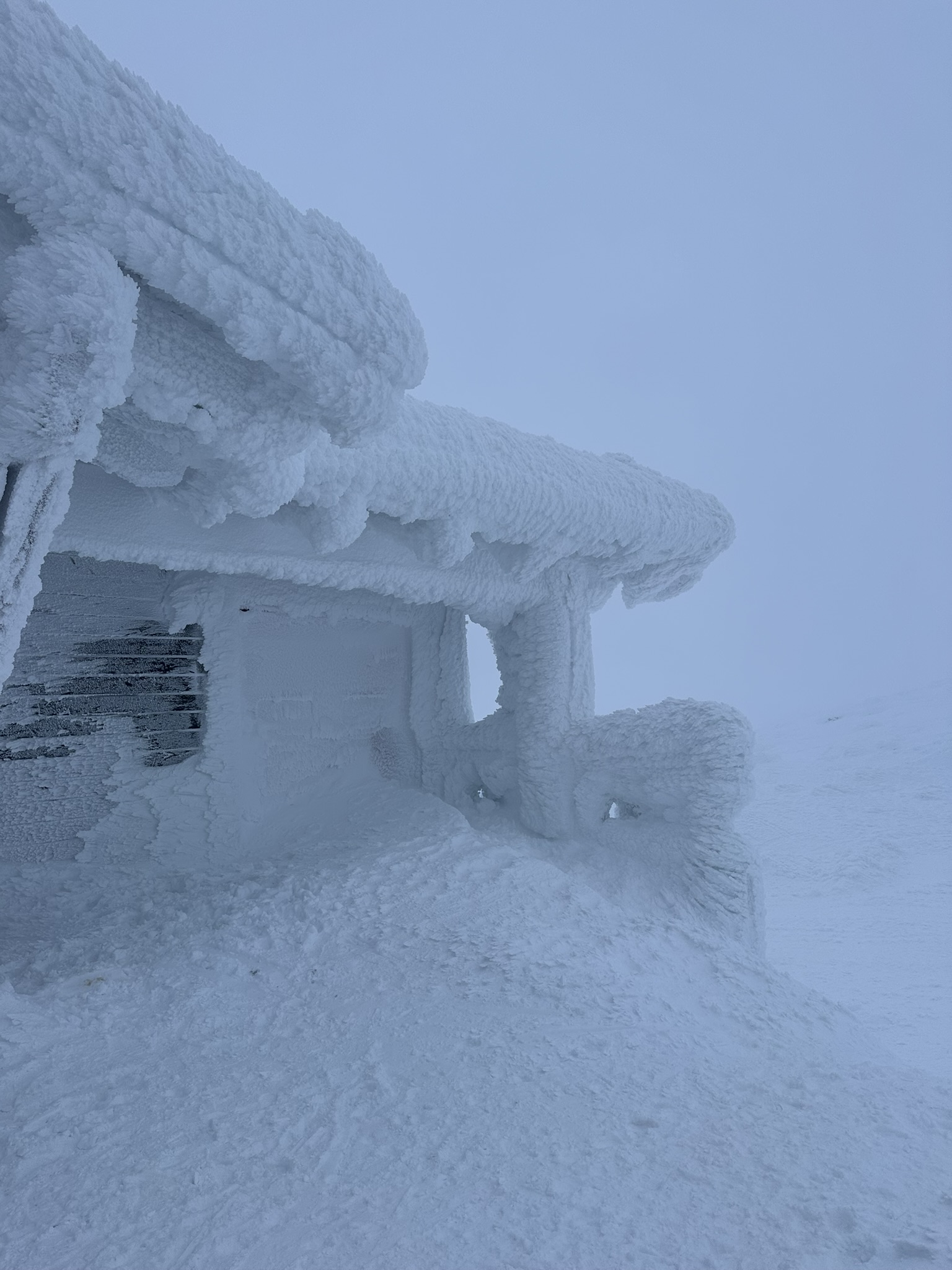 Frost-covered mountain shelter in winter
